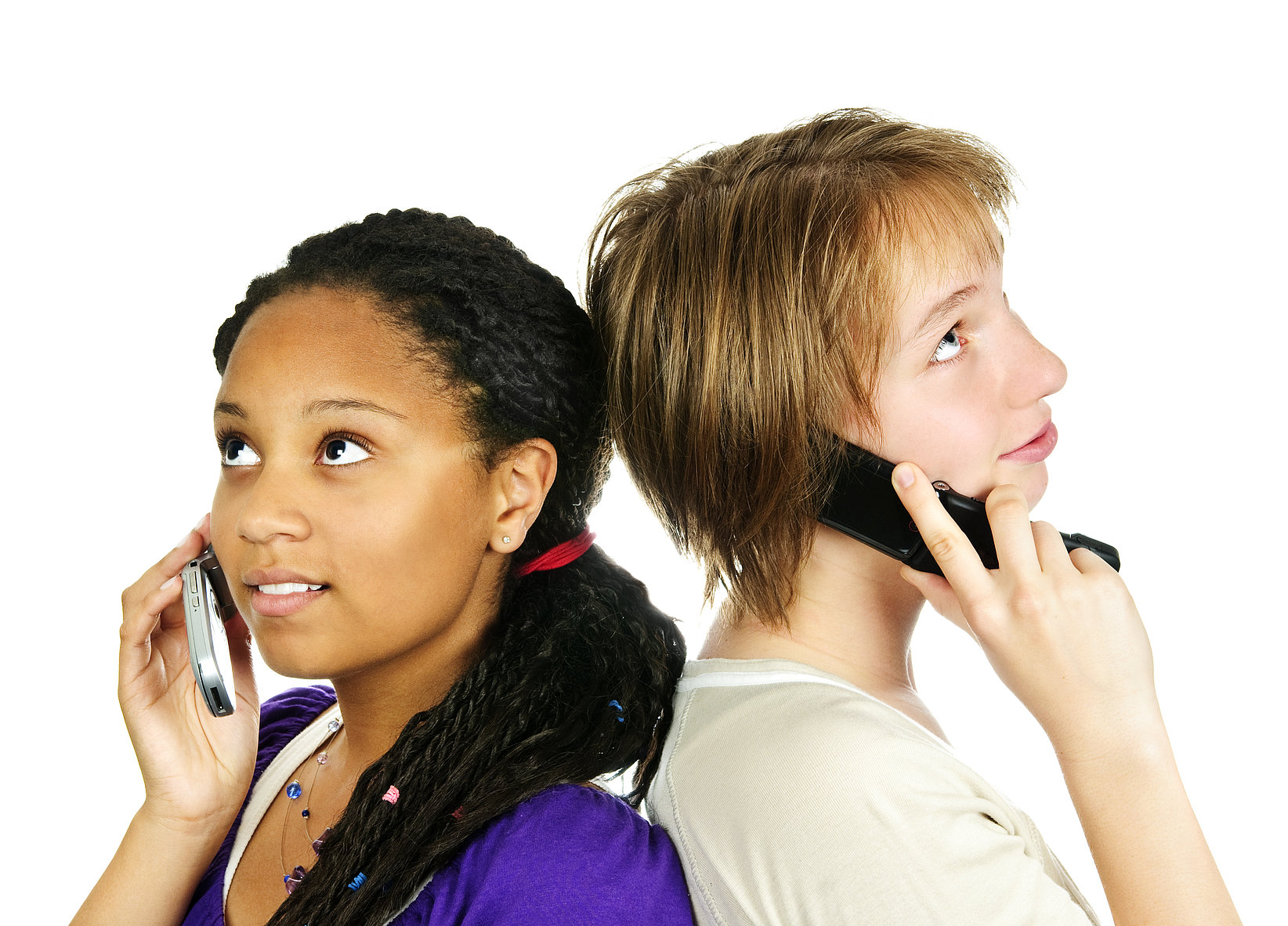 Two teenagers (girl and boy) are standing back to back and talking on an old flip phone.