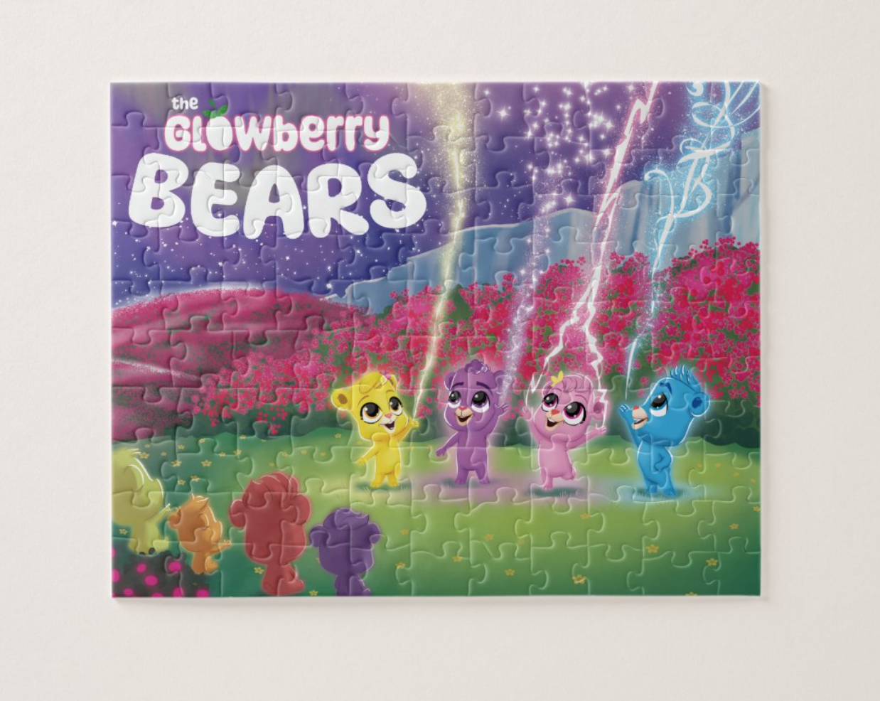 Puzzle from "the Glowberry Bears". The puzzle picture shows the bears in a grassland with flowers in the background.