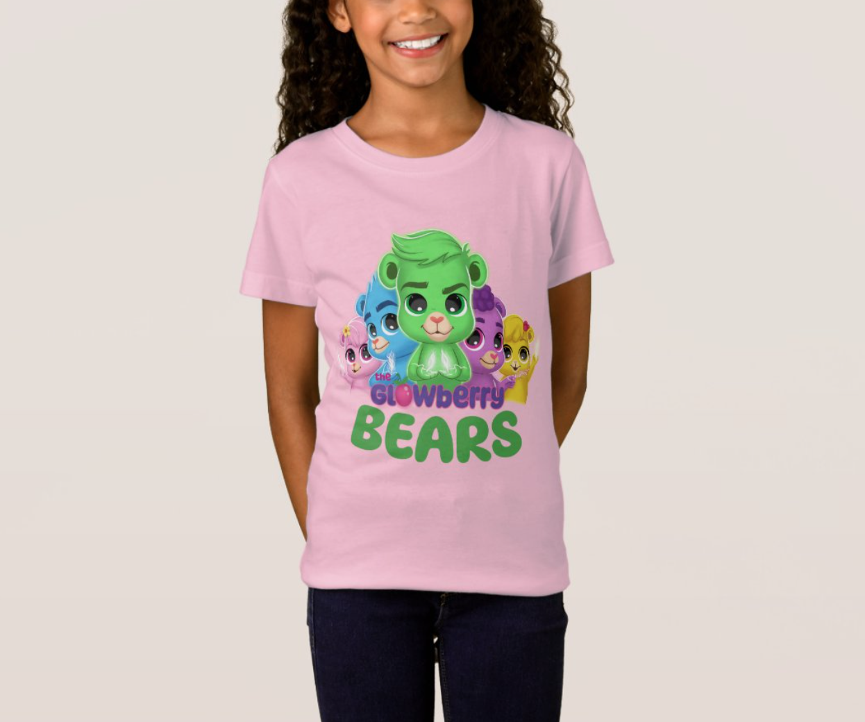 Girl wearing a T-shirt from "the Glowberry Bears" and smiling into the camera.