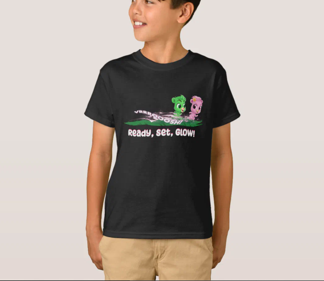 Boy wears a black T-shirt from "the Glowberry Bears" with the inscription "Ready, Set, GLOW!" and smiles.