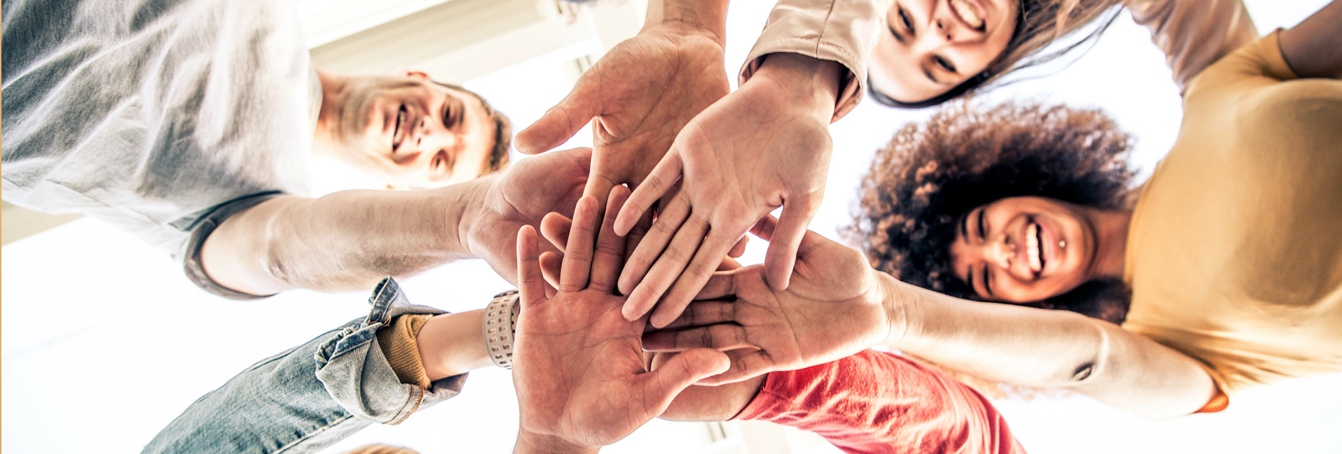 A group of people put their hands together in the center, symbolizing unity and showing that they are a team.