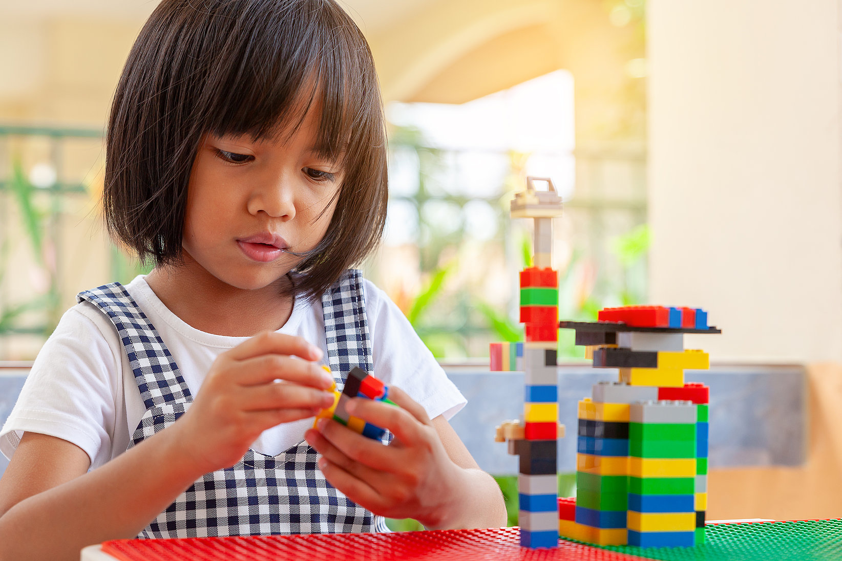 Little girl playing peacefully with "Lego"-building blocks.
